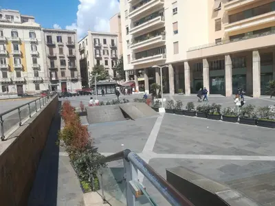 a courtyard in a city with buildings and people at Hostel Tribunale Room Basement in Palermo