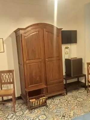 a large wooden cabinet in a room with a television at Hostel Tribunale Room Basement in Palermo