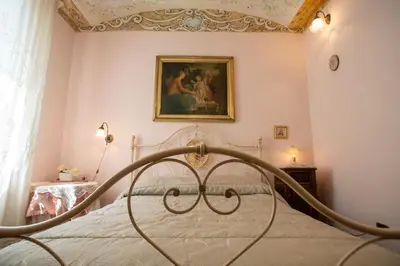 a bedroom with a bed with a painting on the wall at Liberty house in Castellammare del Golfo