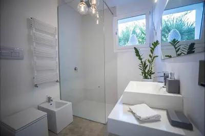a white bathroom with a sink and a shower at Villa Corallo in Cinisi