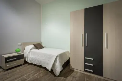 a bedroom with a bed and a cabinet at Villa Gea in Castellammare del Golfo