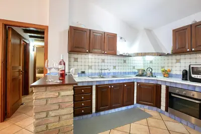 a large kitchen with wooden cabinets and a counter top at Villa Isabella in Castellammare del Golfo