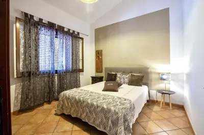 a bedroom with a bed and a large window at Villa Isabella in Castellammare del Golfo