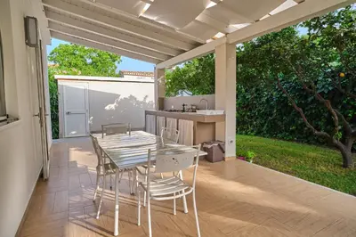 a patio with a table and chairs on a deck at Villa Sicilia in Lascari