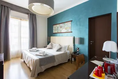 a bedroom with a bed and a blue wall at Residenza Wagner in Palermo