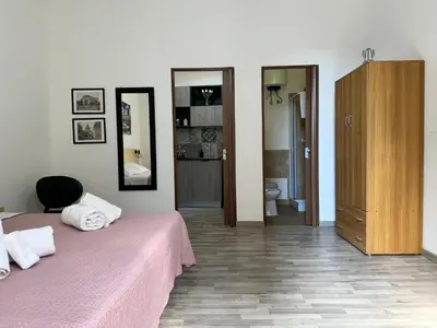 a bedroom with a pink bed and a bathroom at Marilù in Palermo