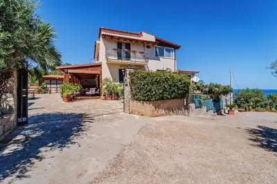 a large house with a fence and a yard at Villa Ficodindia in Altavilla Milicia