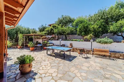 a patio with a table and benches and trees at Villa Ficodindia in Altavilla Milicia