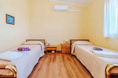 two twin beds in a room with wooden floors at Villa Ficodindia in Altavilla Milicia