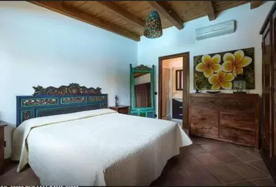 a bedroom with a white bed and a bathroom at RUMAH SAYA in Campofelice di Roccella