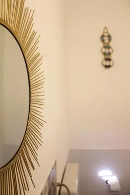 a mirror on a wall next to a table at Narciso Blu in Castellammare del Golfo