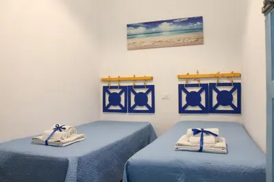 two beds with towels on them in a room at Narciso Blu in Castellammare del Golfo