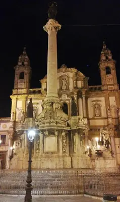 a building with a monument in front of it at night at Amunì in Palermo