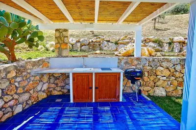 a kitchen with a sink and a stone wall at VILLA ANANDA in Scopello