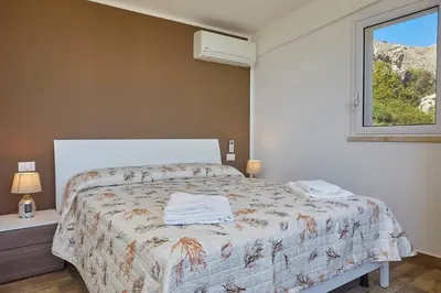 a bedroom with a bed with towels on it at Villa Montemar in Balata di Baida