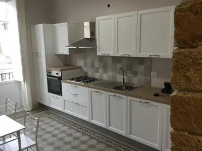 a kitchen with white cabinets and a sink at Le vie del Centro in Palermo