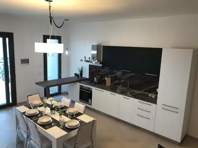 a kitchen with a table with chairs and a dining room at Red Luxury in Borgo Guardiola near Cefalù in Mandra Capreria