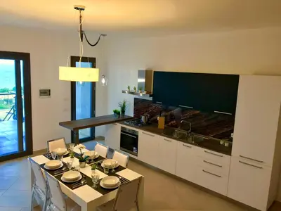 a kitchen with a table and a dining room at Red Luxury in Borgo Guardiola near Cefalù in Mandra Capreria