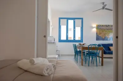 a room with a bed and a dining room at Casa Azzurra sul mare e centralissima in San Vito lo Capo