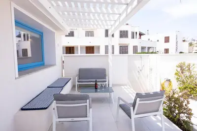 a balcony with chairs and a table and a window at Casa Azzurra sul mare e centralissima in San Vito lo Capo