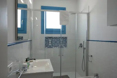 a bathroom with a shower and a toilet and a sink at Casa Blu sul mare e centralissima in San Vito lo Capo