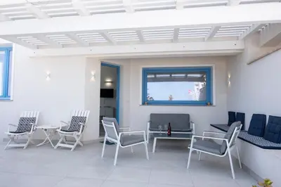 a room with chairs and a table and a window at Casa Blu sul mare e centralissima in San Vito lo Capo