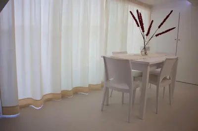 a white dining room table with chairs and a vase on it at Duchessa House in Castellammare del Golfo