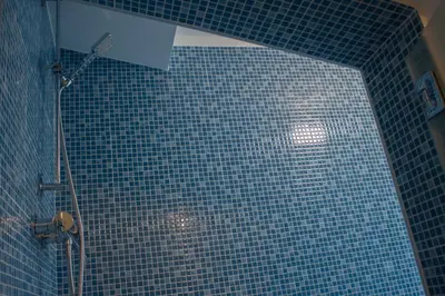 a blue tiled bathroom with a shower with a blue tile wall at Duchessa House in Castellammare del Golfo