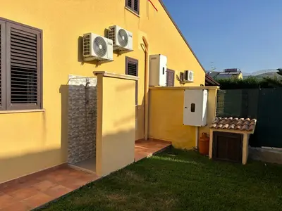 a yard with a porch and a lawn at Residence le Coccinelle vicino a Cefalù in Campofelice di Roccella
