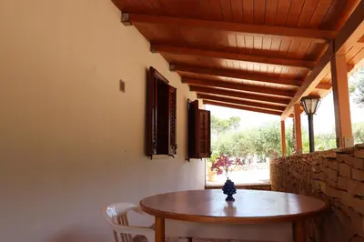 a wooden table and chairs in a room at EVEN HAVEN Baglio in San Vito lo Capo