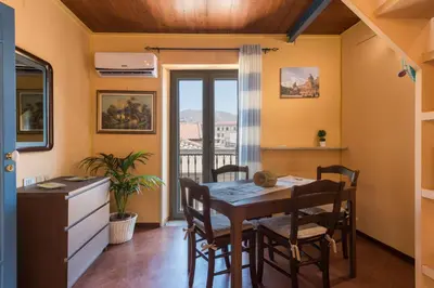 a dining room with a table and chairs and a window at The Normans Apartments in Palermo
