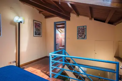 a bedroom with a blue bed and a staircase at The Normans Apartments in Palermo