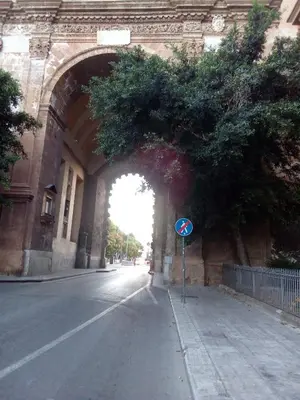 an archway in a building with a street sign under it at All'Ombra di Porta Nuova in Palermo