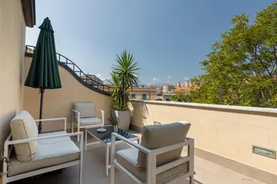a balcony with two chairs and a table and an umbrella at I Mori di Porta Nuova Suite & Terrace in Palermo