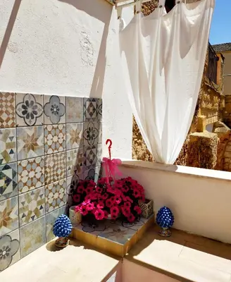 a flower arrangement on a balcony with a white curtain at Le terrazze segrete in Palermo