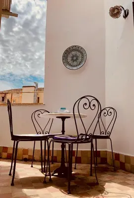 two chairs and a table and a plate on a wall at Le terrazze segrete in Palermo