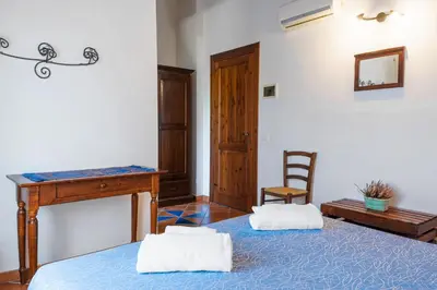 a bedroom with a bed and a desk and a chair at Casale Ginisara in Castellammare del Golfo
