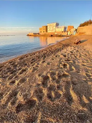 a beach with footprints in the sand and water at Casa 