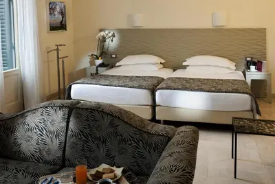 a hotel room with two beds and a couch at Hotel Garibaldi in Palermo