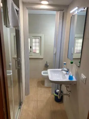 a bathroom with a sink and a toilet and a mirror at Tiny House Basilio in Palermo