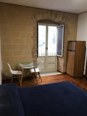a dining room with a table and chairs and a kitchen at Tiny House Basilio in Palermo