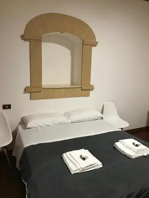 a bedroom with a bed with two towels on it at Tiny House Basilio in Palermo