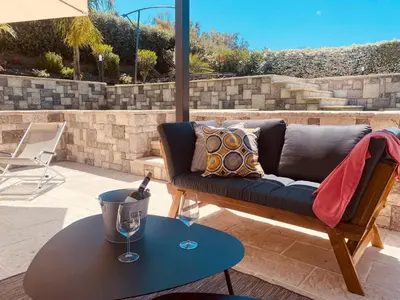 a couch on a patio with a table and wine glasses at flAle's holiday house in Cefalù