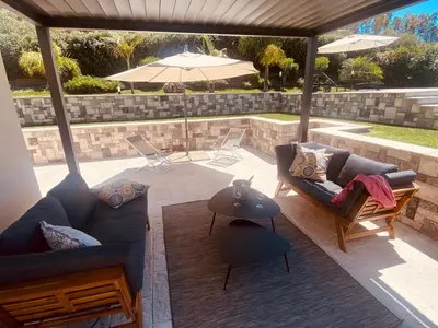 a patio with two couches and an umbrella at flAle's holiday house in Cefalù