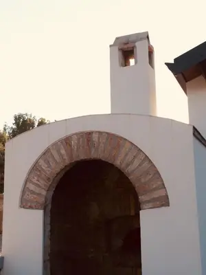 an archway in a white building with a clock tower at flAle's holiday house in Cefalù