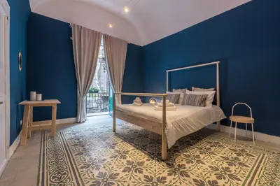 a bedroom with blue walls and a bed at Qasr Home Beautiful apartment in Palermo in Palermo
