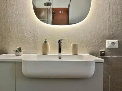 a bathroom with a white sink and a mirror at Qasr Home Beautiful apartment in Palermo in Palermo