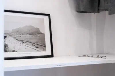 a picture of a beach in a picture frame on a shelf at Qasr Home Beautiful apartment in Palermo in Palermo