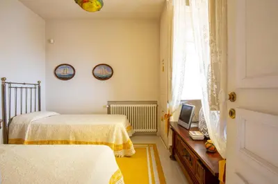 a bedroom with two beds and a television in it at Solemar Sicilia - Casa Porto Bagnera in Santa Flavia