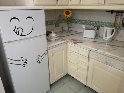 a kitchen with a refrigerator with a smiley face drawn on it at A casa di Zara in Termini Imerese